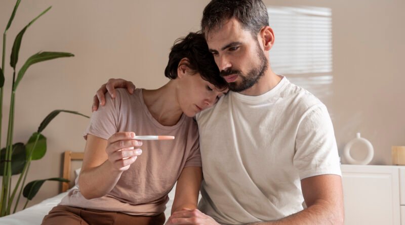 Couple sitting apart looking stressed due to infertility struggles