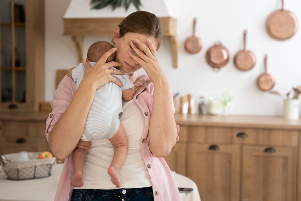 Mother struggling with postpartum depression holding baby
