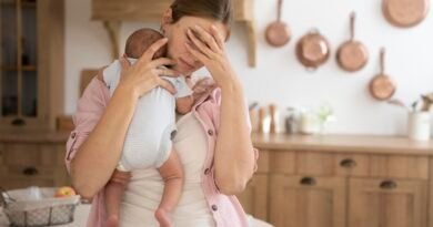 Mother struggling with postpartum depression holding baby