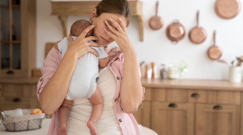Mother struggling with postpartum depression holding baby