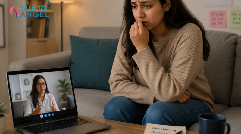 Young woman sitting anxiously on a sofa during a session with an online anxiety counsellor, showing signs of restlessness and emotional stress.