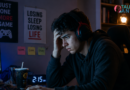 Young man looking stressed while gaming online late at night, showing signs of gaming & gambling addiction & emotional distress.